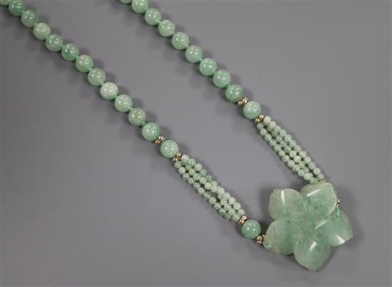 A green quartzite bead necklace with carved quartzite flower head motif, 78cm.